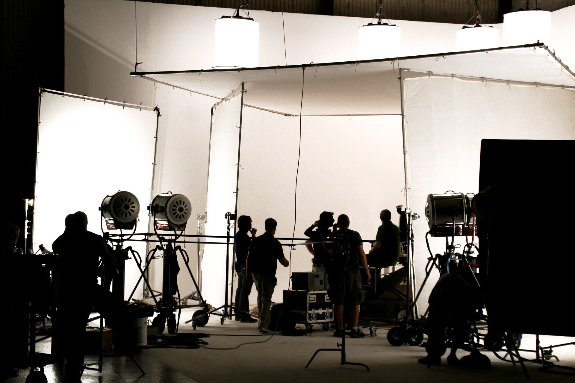 Film studio set with lights and crew silhouettes